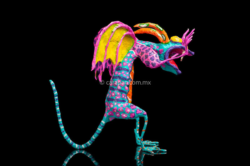 User  Please create a selling description for Paper Mache Alebrije Dragon Style Standing with hands up and mouth open showing 2 fangs popping yellow eyes and two orange horns. His body is painted in turquoise with pink dots and blue stripes and his wings are yellow outlined in pink