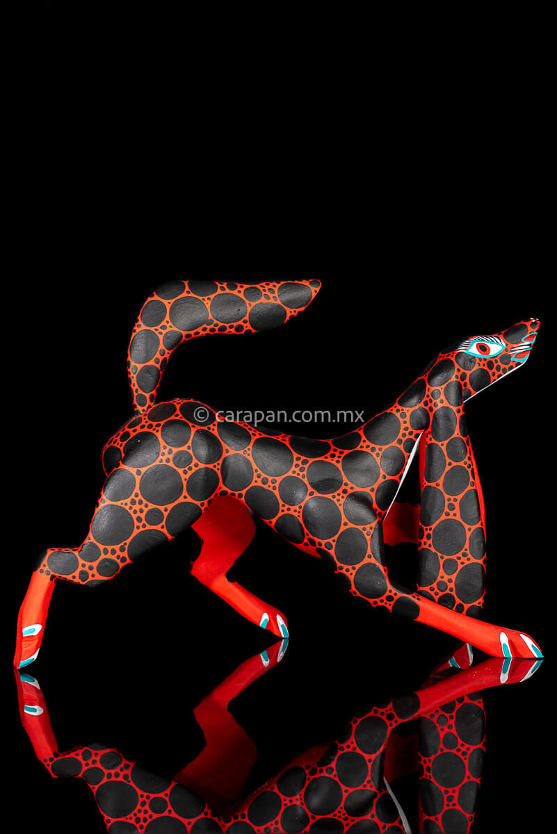 Red dog wood carving decorated with black dots Oaxacan Alebrije