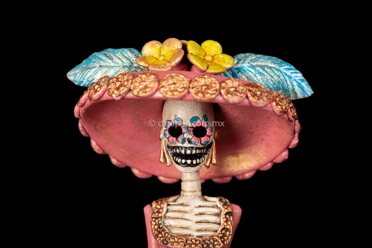 Day of the dead Sculpture, Catrina wearing a pink dress with flowers at the bottom and a traditional Posada Style hat