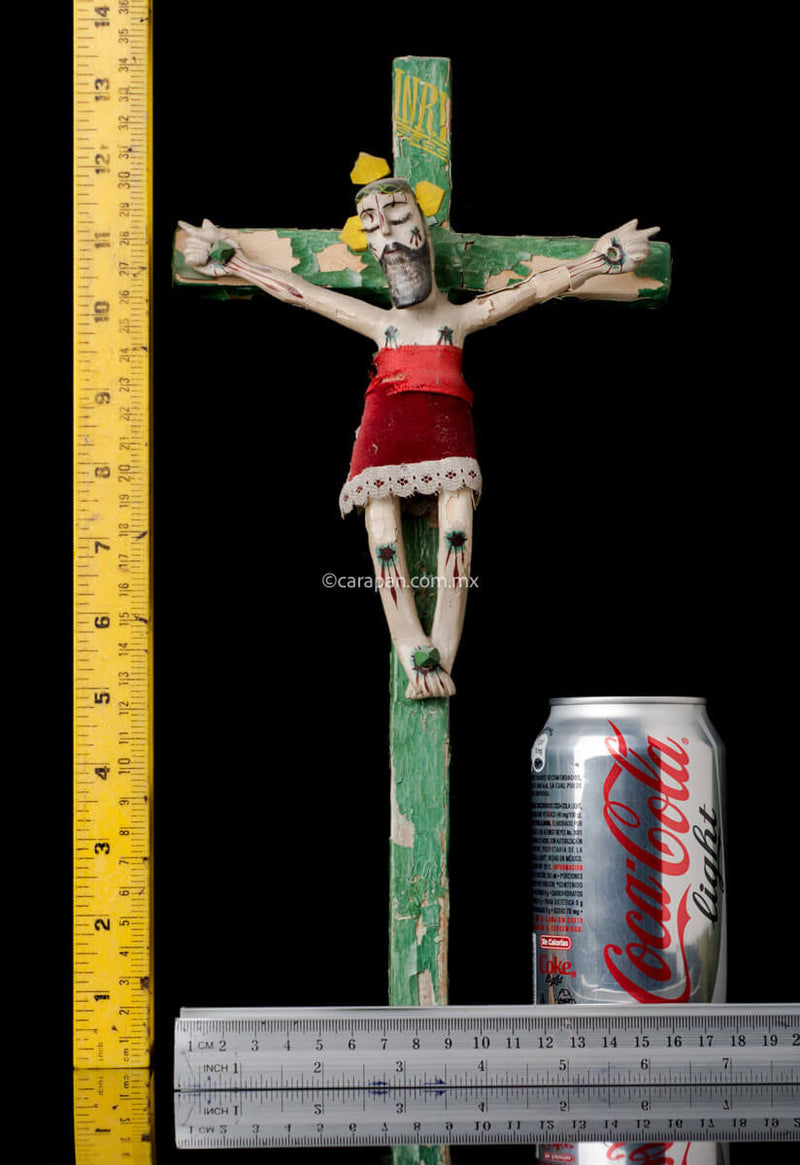 Vintage Lacquered Wood Cross with Christ Crafted in Olinalá, Guerrero. The cross is green The lacquer presents some peeled off areas. The christ wears a red cloth from the waist to his knees.  Rulers