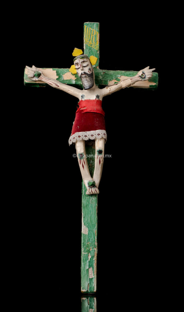 Vintage Lacquered Wood Cross with Christ Crafted in Olinalá, Guerrero. The cross is green The lacquer presents some peeled off areas. The christ wears a red cloth from the waist to his knees. 