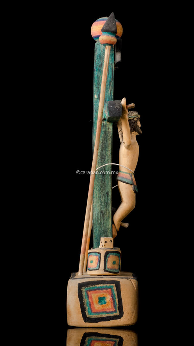 Hand Carved Wooden Cross on a platform with elements of the passion such as a spear, a sponge (used to give him vinegar) and the dice. The cross is painted in green and the decor is very simple, naive style with a christ with smiling expression.  Side 2